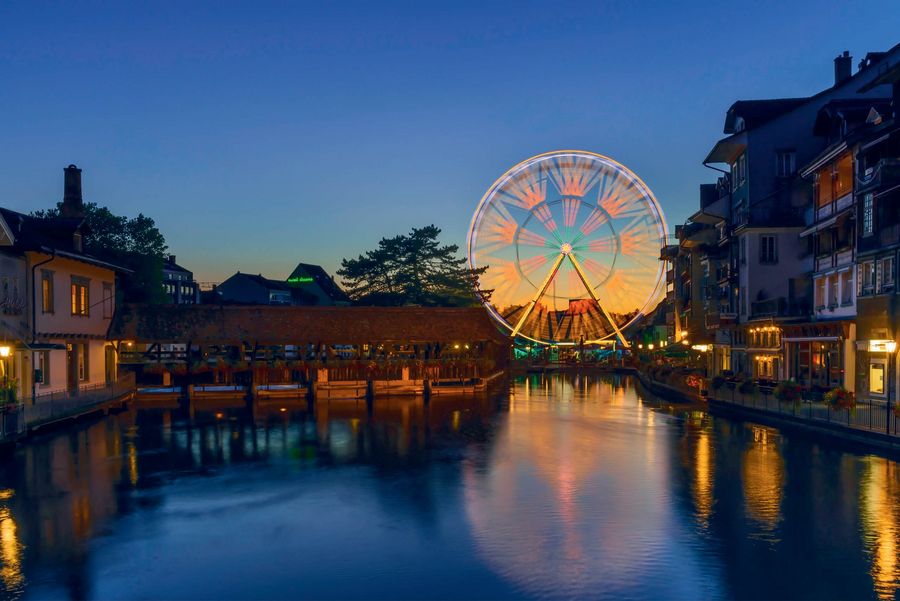 Blick von der Aare mit dem sich im Wasser spiegelnde Riesenrad am Thunfest in Thun