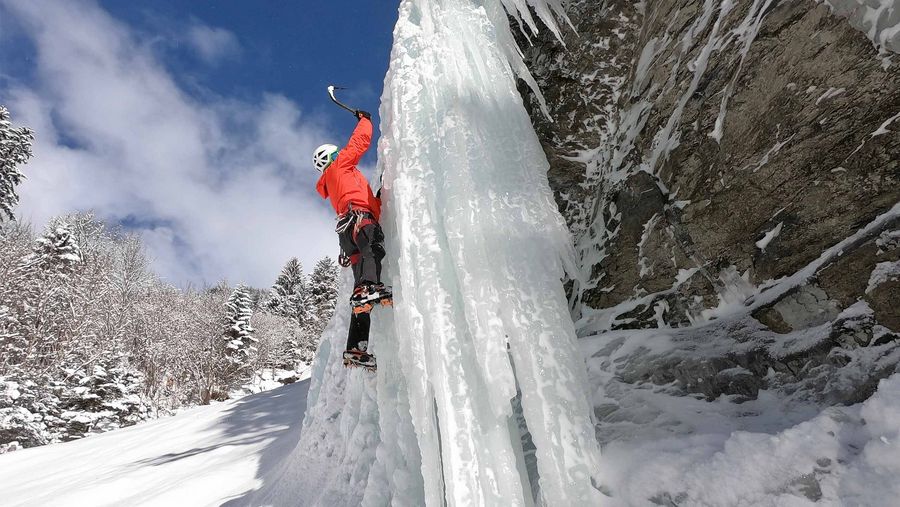 Kletterer klettert mit zwei Eispickel eine Gletscherschlucht hoch