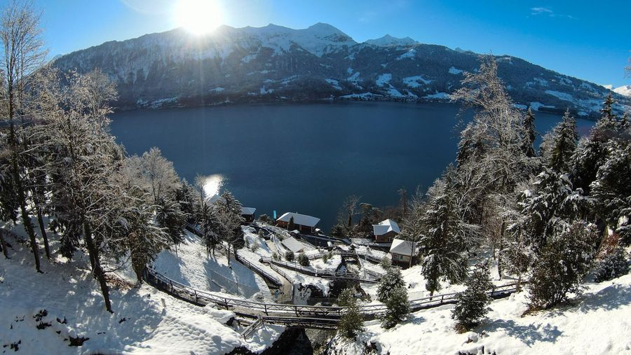 Aussicht von den St. Beatus-Höhlen auf den Thunersee, die Berge dahinter und die verschneite Umgebung an einem sonnigen Wintertag