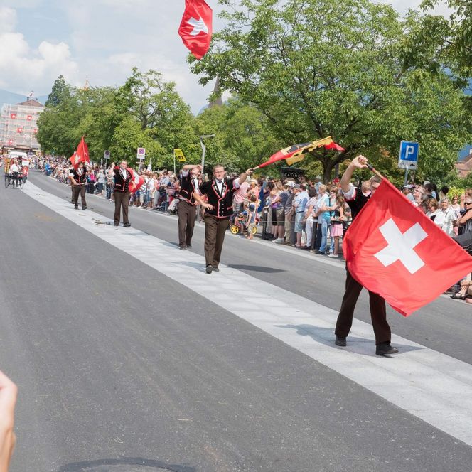 Am Festumzug werden Schweizer Fahnen in die Luft gewirbelt