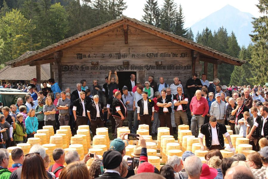 Älpler losen Käse aus vor dem Speicher auf einer Alpweide im Justistal