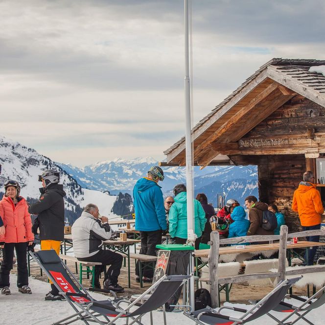 Wintersportler bei einer Skihütte auf der Windegg im Wintersportgebiet Axalp.