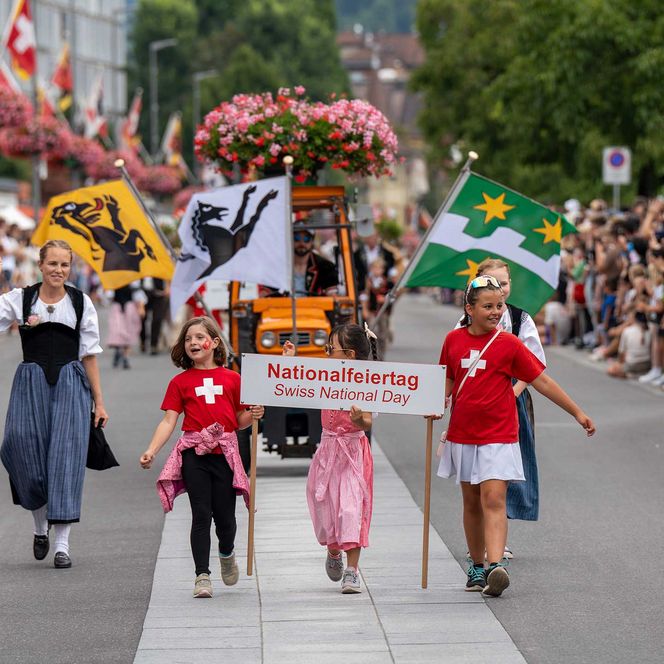 Kinder in Schweiz T-Shirts oder Tracht führen den 1. August Umzug an.