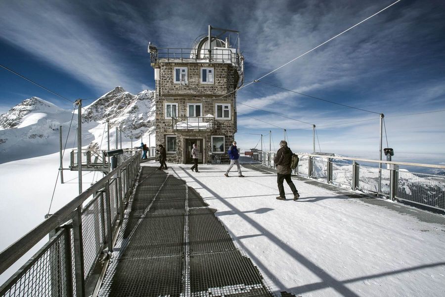 Plattform auf der Sphinx-Aussichtsterrasse vor verschneiter Berglandschaft auf dem Jungfraujoch