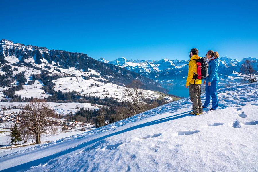 Ein Paar wandert in der stimmungsvollen Winternatur und bewundert die verschneite Naturkulisse