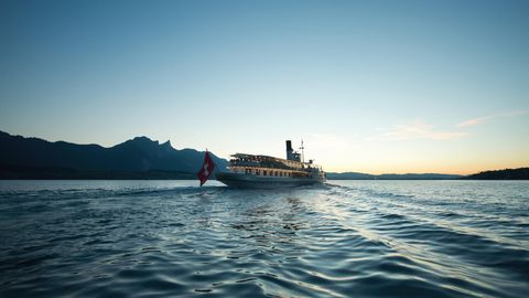 Das Dampfschiff Blümlisalp fährt in der Abendstimmung über den blauen Thunersee