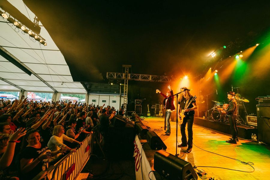 Band auf der beleuchteten Bühne vor Fans am Brienzersee Rockfestival