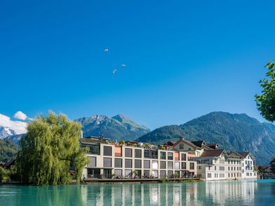 Interlaken an der Aare mit Paraglidern im Hintergrund Interlaken an der Aare mit Paraglidern im Hintergrund