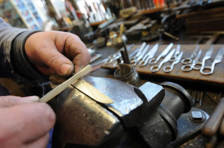 Manfred Schoder demonstriert wie ein Messer geschliffen wird auf einer Stadtführung