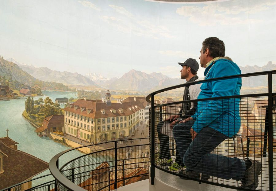 Zwei Besucher bestaunen das eindrückliche Rundbild der Stadt Thun von der zentrierten Plattform aus