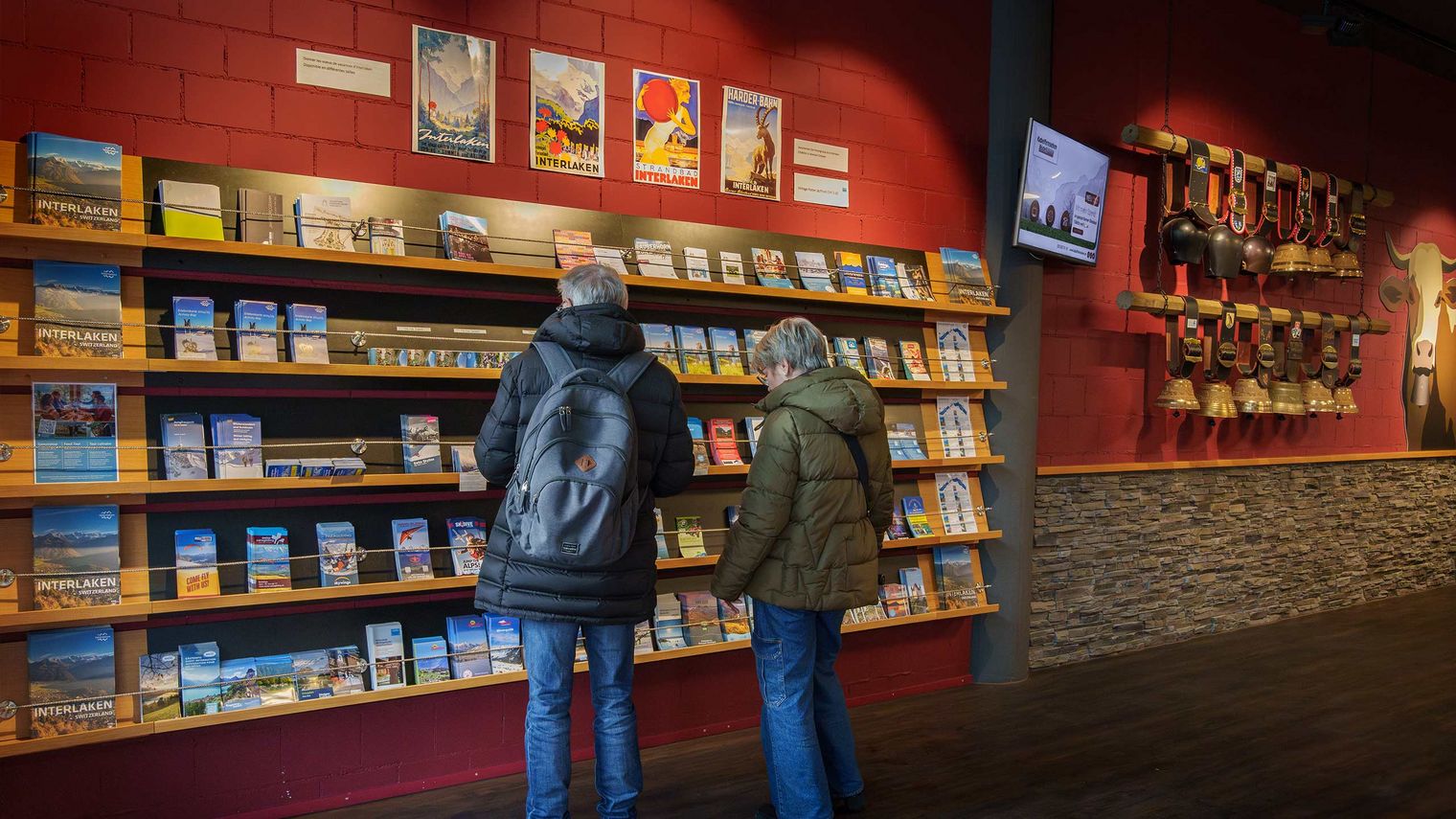 Gäste vor der Prospektwand in der Tourist Informatmion Interlaken