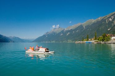 Familie unternimmt eine Pedalofahrt auf dem Brienzersee und bestaunt das Bergpanorama rundherum