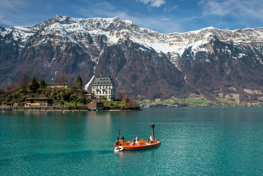 HotTug schippert mit zwei Frauen und zwei Männern auf dem Brienzersee vor der Seeburg Iseltwald