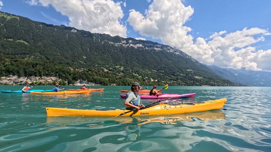 Ein Gruppe mit Kajak von Hightide paddelt über den Brienzersee.