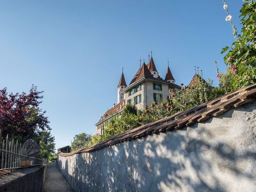 Der Aufstieg führt über Treppen hinauf zum Schlossberg, wo das Schloss Thun in der strahlenden Sonne thront