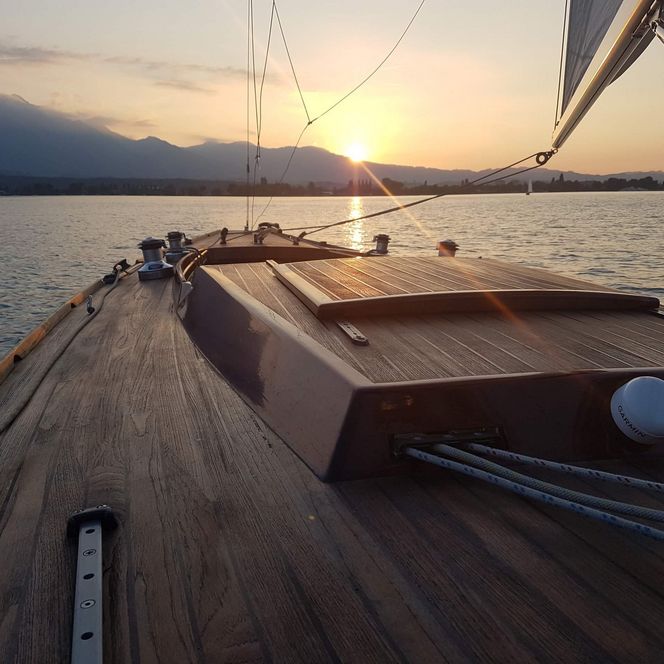 Segelboot welches auf dem Thunersee während dem Sonnenuntergang unterwegs ist