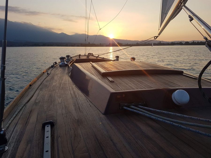 Segelboot welches auf dem Thunersee während dem Sonnenuntergang unterwegs ist