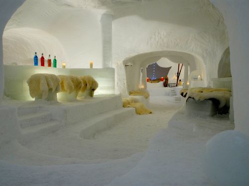 Innenansicht Iglu mit Tischen und Bänken aus weissem Eis mit stimmungsvoller Beleuchtung