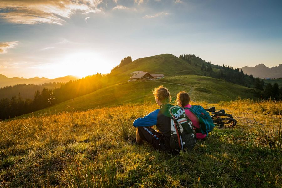 Zwei Biker ruhen sich während dem Sonnenuntergang auf der Lombachalp aus