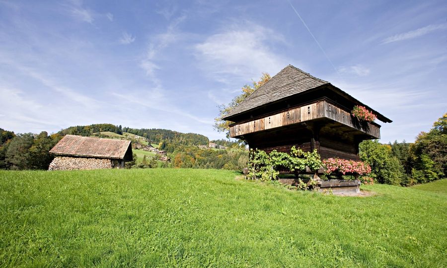 Traditioneller Spycher im Dorf Heiligenschwendi auf einer grünen Wiese im Sommer