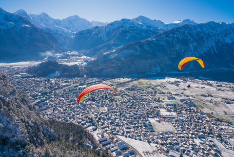 Paragliding über dem verschneiten Interlaken mit Blick auf die Berge