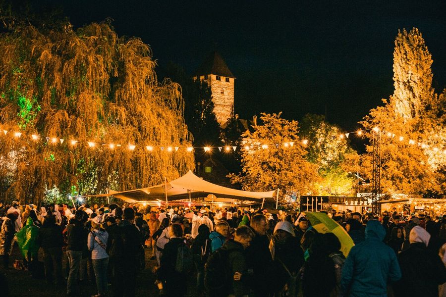 Stände und beleuchtete Bäume in der Spiezer Bucht mit Blick auf das Schloss Spiez