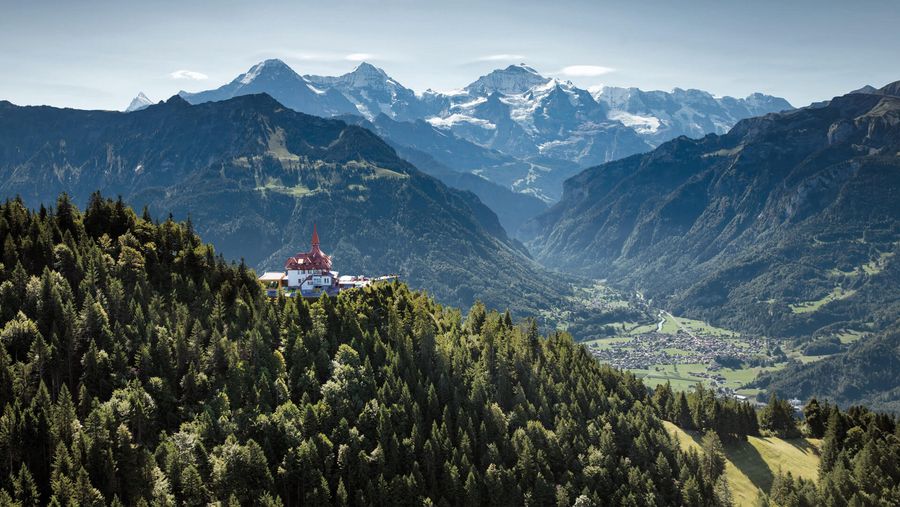 Blick auf das Restaurant Harder Kulm mit Eiger, Mönch und Jungfrau im Hintergrund