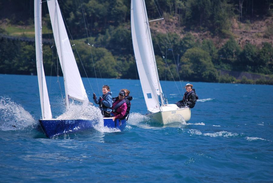 Zwei weisse Segelboote segeln auf dem blauen Thunersee