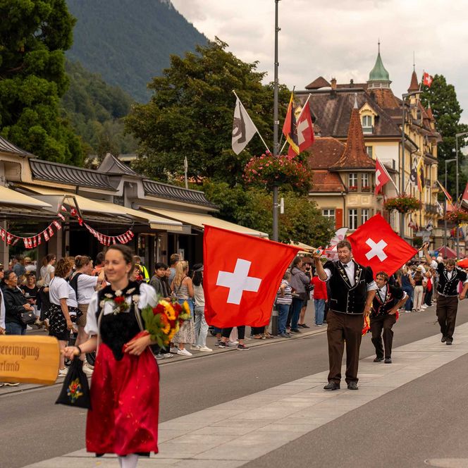 Angeführt von Trachtenfrauen zeigen Fahnenschwinger ihr Können am 1. August Umzug