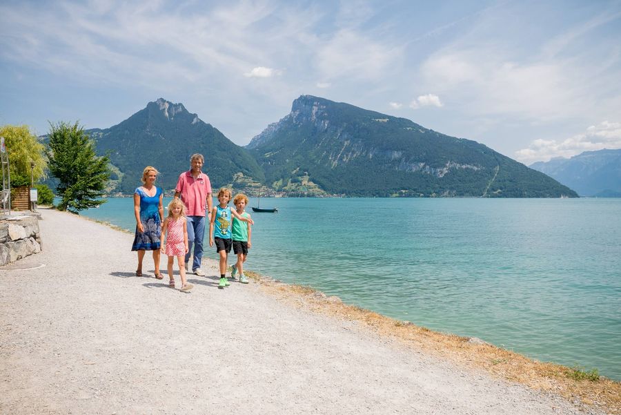 Familie spaziert entlang des Thunersees auf dem Strandweg von Spiez nach Faulensee