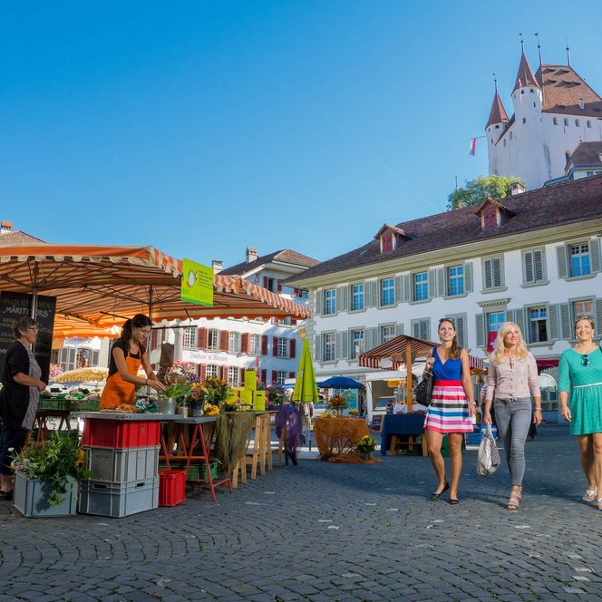 Freundinnen flanieren über den vielseitigen Markt auf dem Rathausplatz in Thun