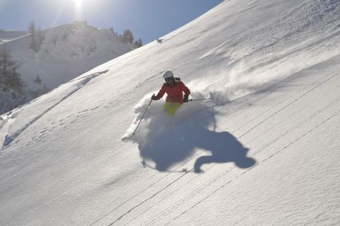 Skifahrer fährt während einer Skitour durch den weissen Tiefschnee