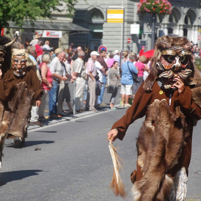 Maskierte Personen laufen am Festumzug vom 1. August durch Interlaken