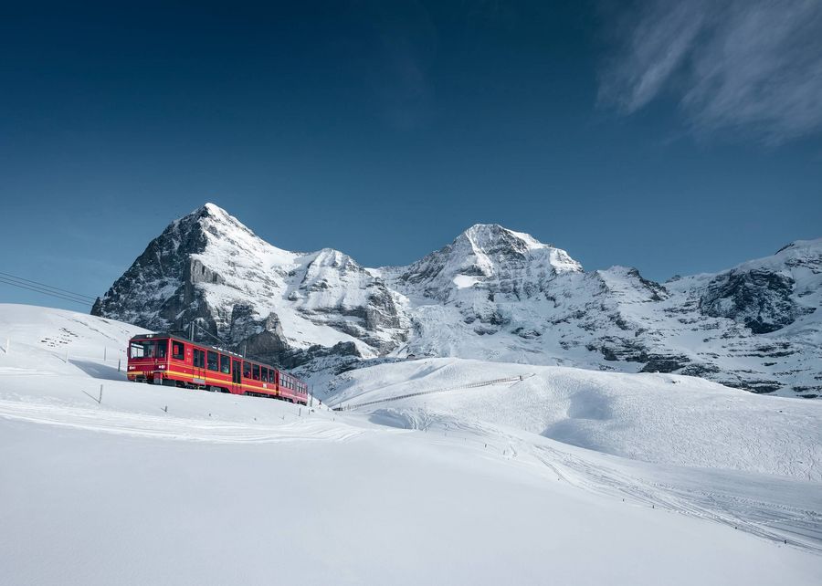 Jungfraubahn vor Eiger und Mönch in verschneiter Winterlandschaft