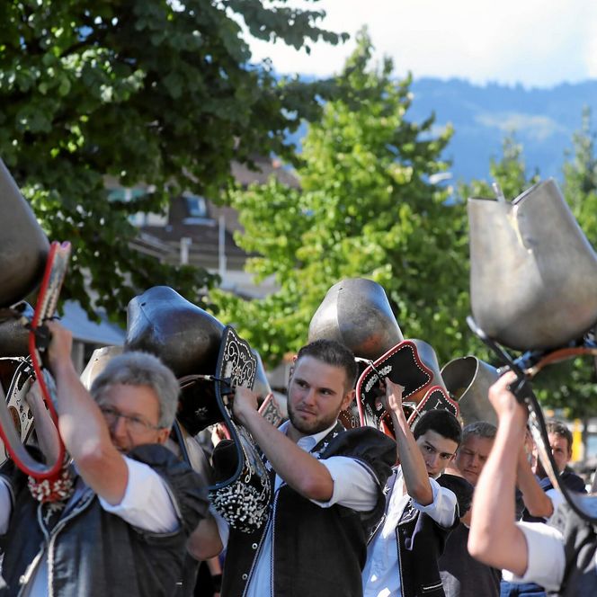 Trychler laufen mit schwingenden Schweizer Glocken durch Interlaken
