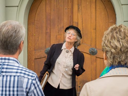 Stadtführerin vor einer Schule während der Stadtführung Männerräume Frauenträume
