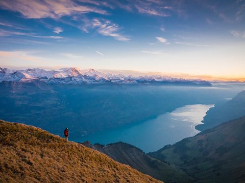 Wanderer blickt über den Brienzersee und geniesst die Abendstimmung