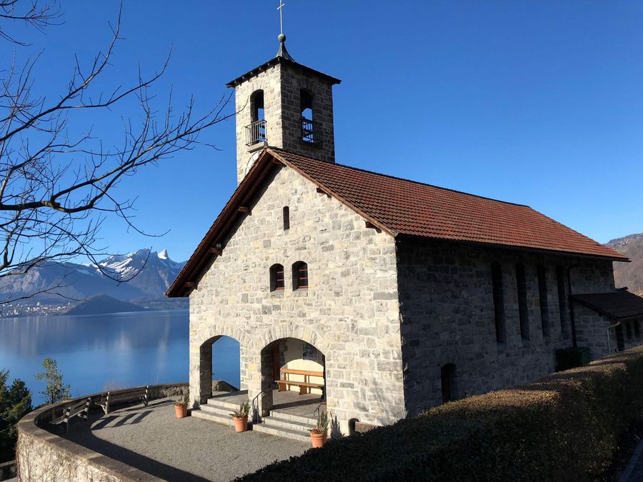 Kirche von Merligen thront leicht erhöht im Dorf mit Blick über die wunderschöne Berg- und Seelandschaft