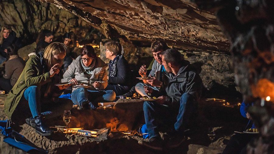 Mehrere Personen essen ein Höhlenraclette in den St. Beatus-Höhlen